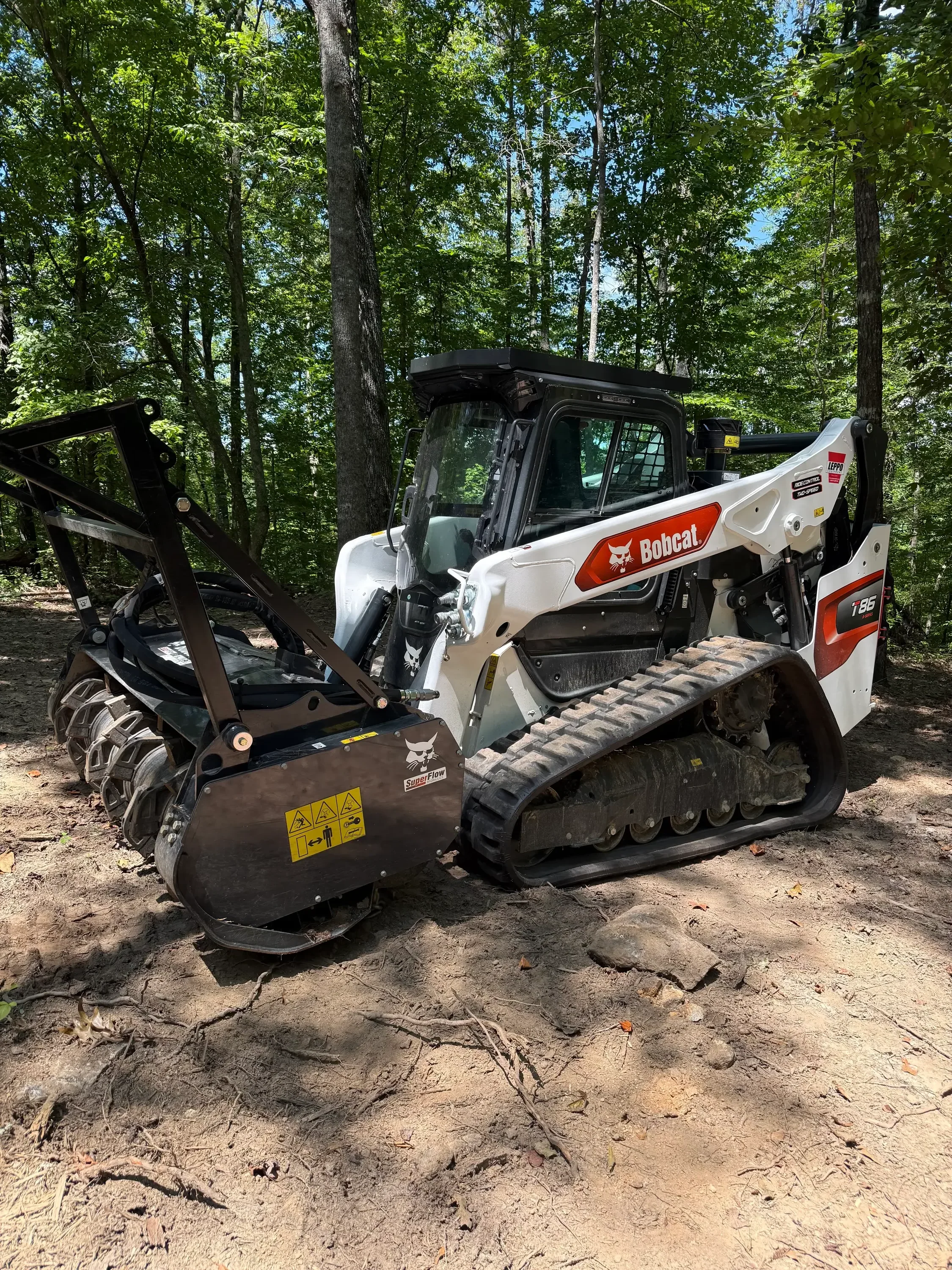 Heavy equipment and machinery staged for land clearing and forestry work, showing the tools and fleet used for professional site preparation.